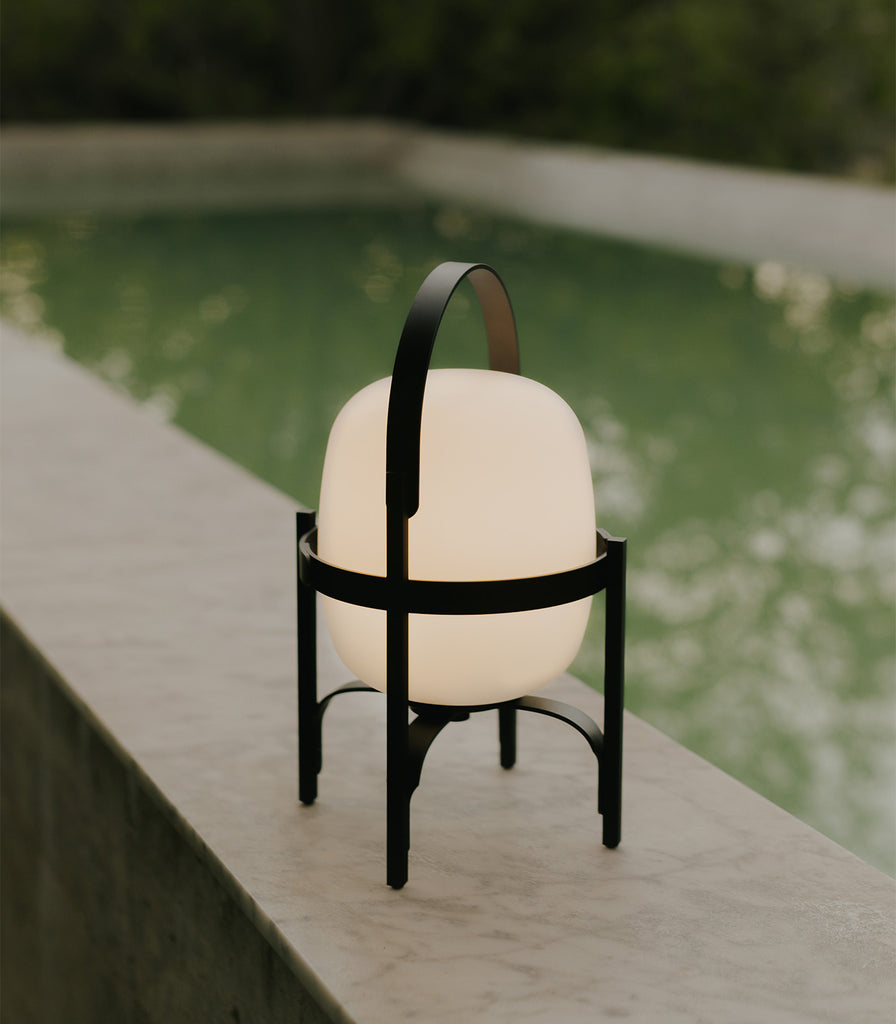 Santa & Cole Cestita Alubat Portable Table Lamp featured within outdoor space