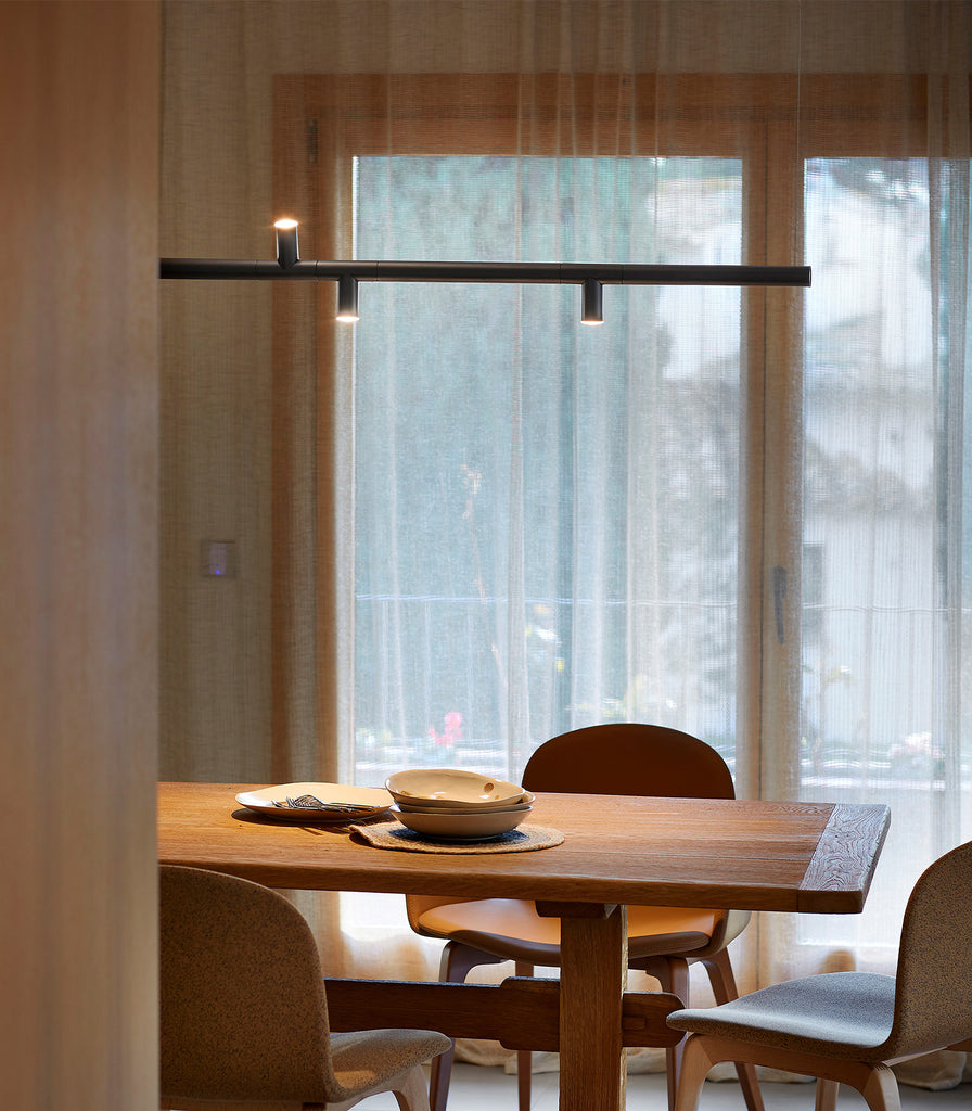 Estiluz Morse Linear Pendant Light hanging over dining table